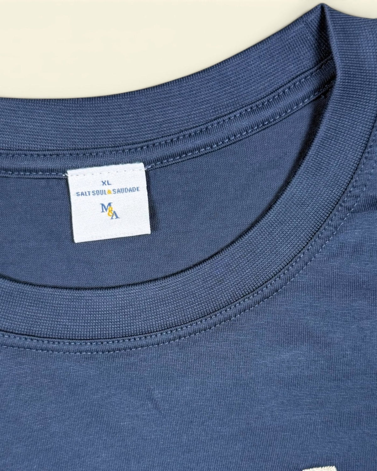 The custom woven neck label inside the navy collar.