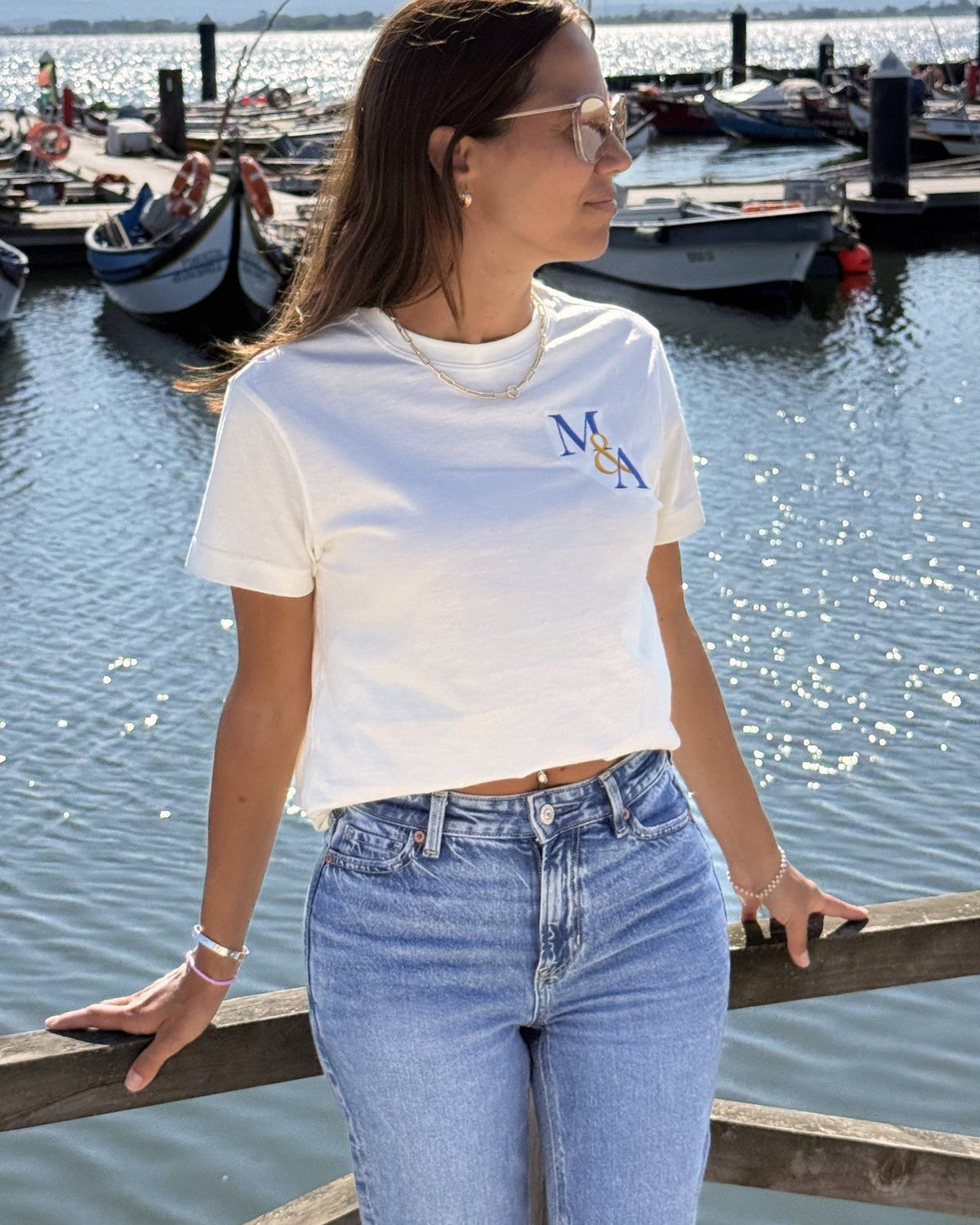 The Founders Tee in cream worn at the harbour, M&A monogram embroidered at the left chest.